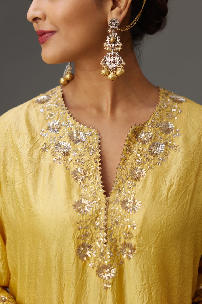 Yellow hand crushed silk straight kurta set highlighted with gold sequins and zari handwork.