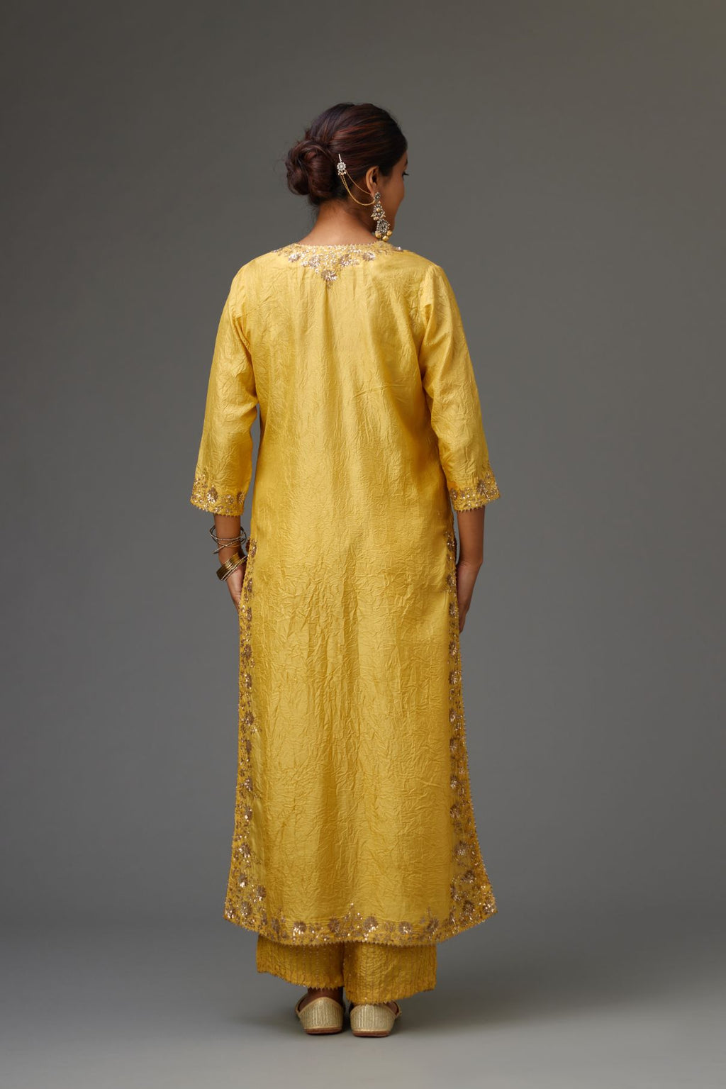 Yellow hand crushed silk straight kurta set highlighted with gold sequins and zari handwork.