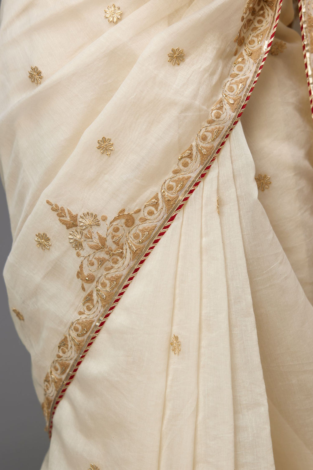Off-white cotton chanderi saree set with all-over dori and gota embroidery, highlighted with gold sequins, paired with silk chanderi hand block printed choli with all-over gota detailing.