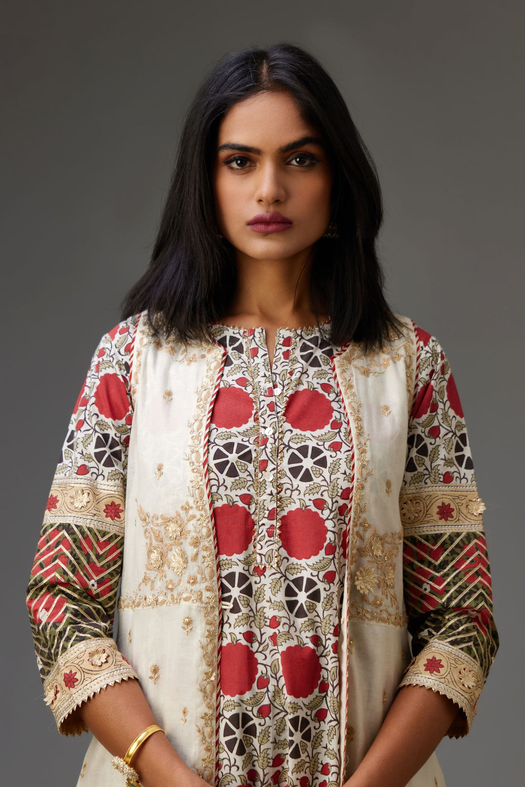 Off white cotton chanderi front open sleeveless jacket set with dori and gota embroidery detailing, highlighted with gold sequin work.