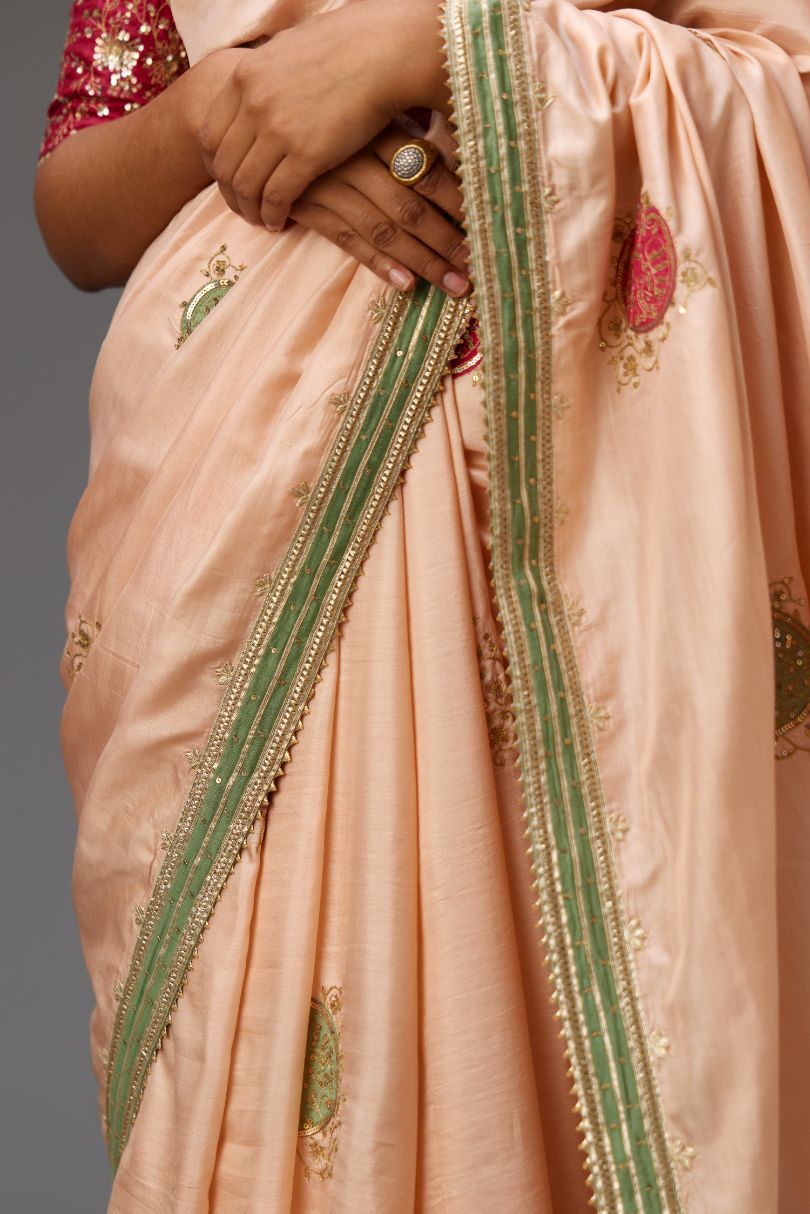 Pink silk saree set highlighted with all-over sequins embroidered boota and contrast colored border running along all edges.