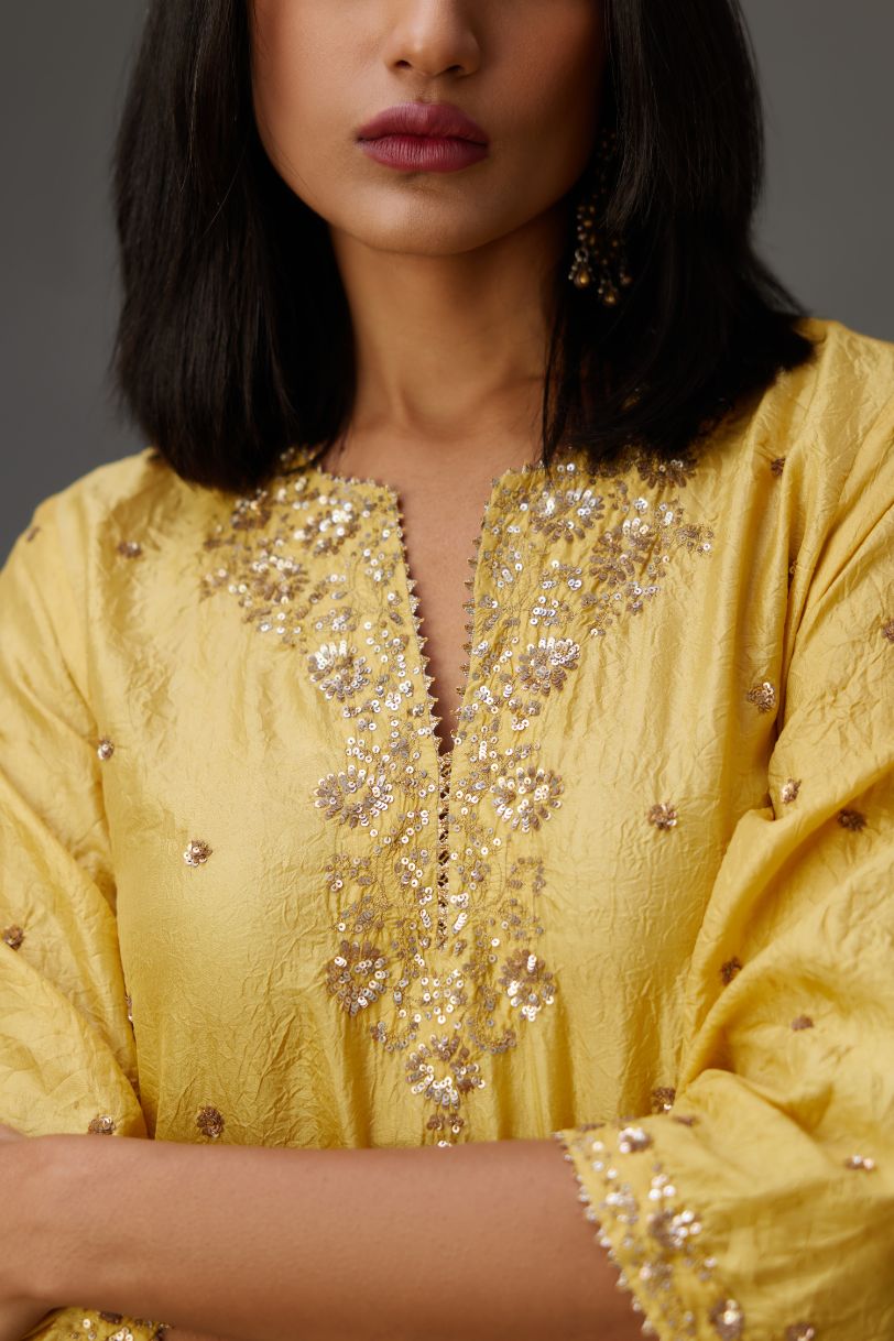 Yellow hand crushed silk short kurta set with all-over gold sequins and zari handwork, highlighted with gota lace at edges.