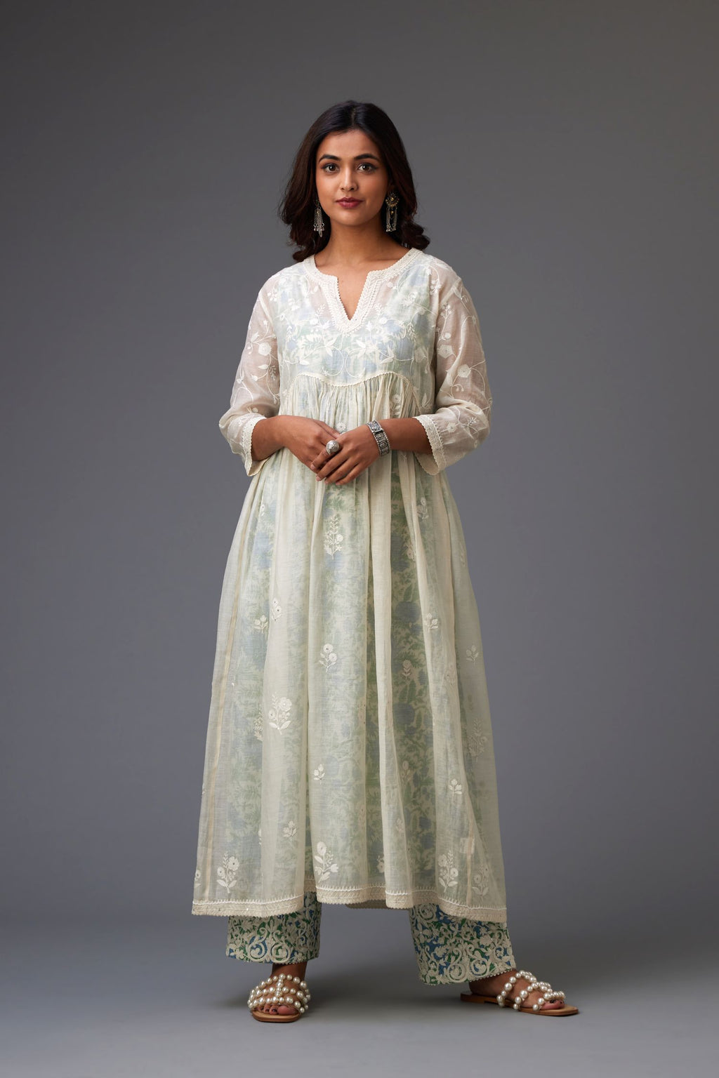 Cotton chanderi kurta set with wavy empire waistline and gathers, highlighted with all-over tonal colored thread embroidery and ric-rac detail.