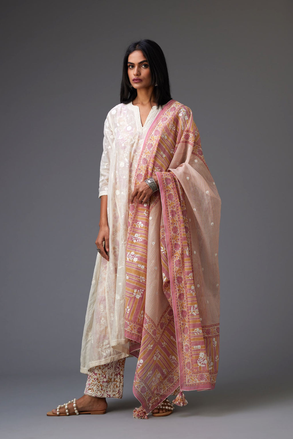 Off white cotton chanderi kurta set with asymmetric hem, highlighted with tonal colored thread embroidery and ric-rac lace at edges.