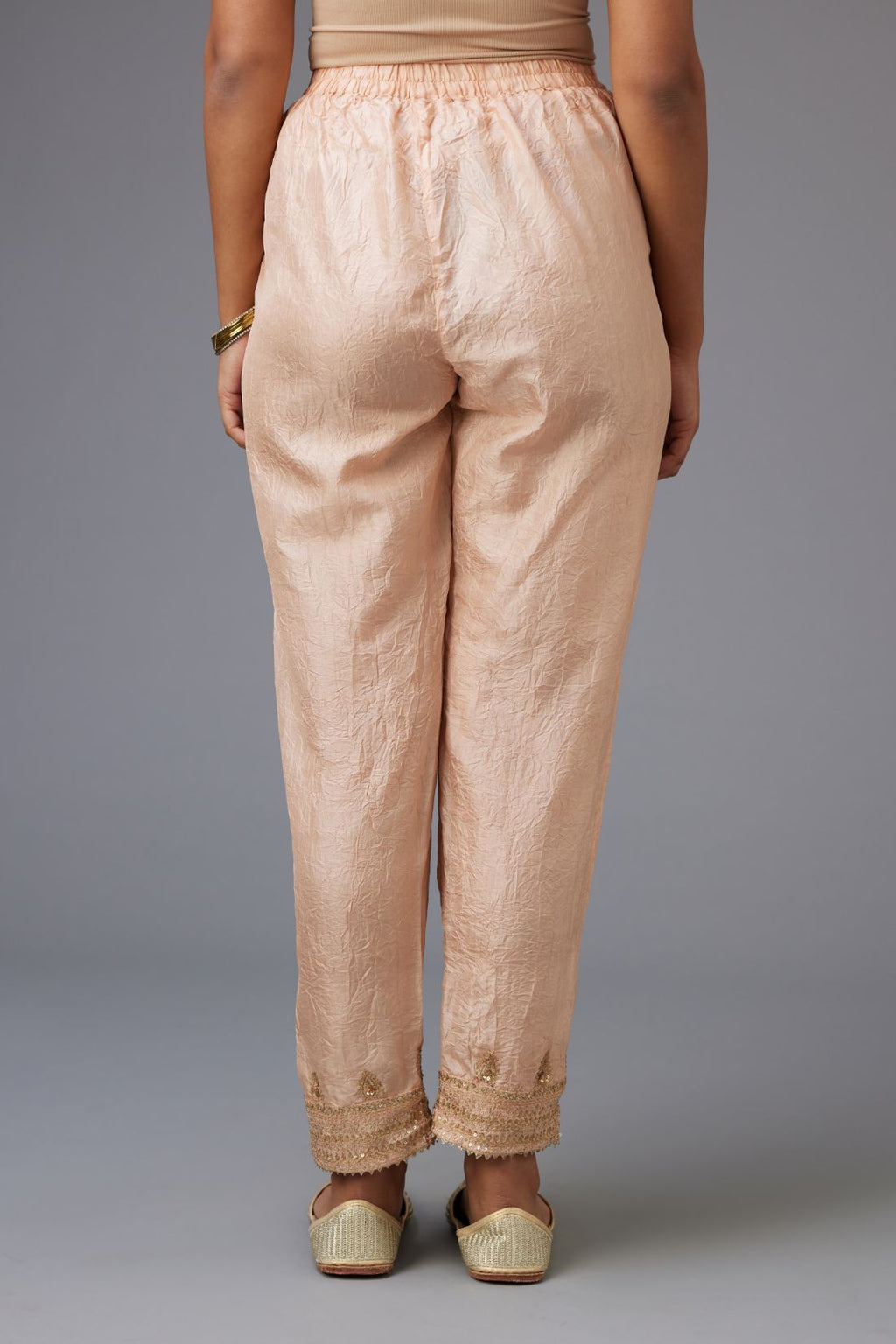 Pink hand crushed silk pants with embroidered sequins border at hem.
