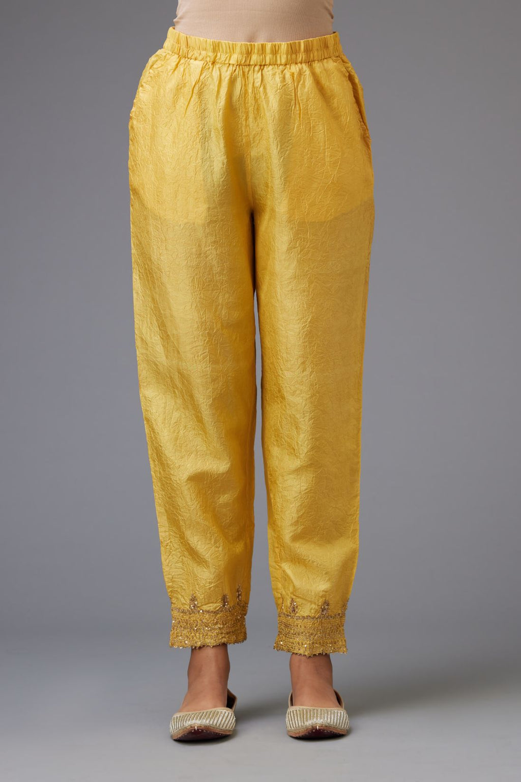 Yellow hand crushed silk pants with embroidered sequins border at hem.