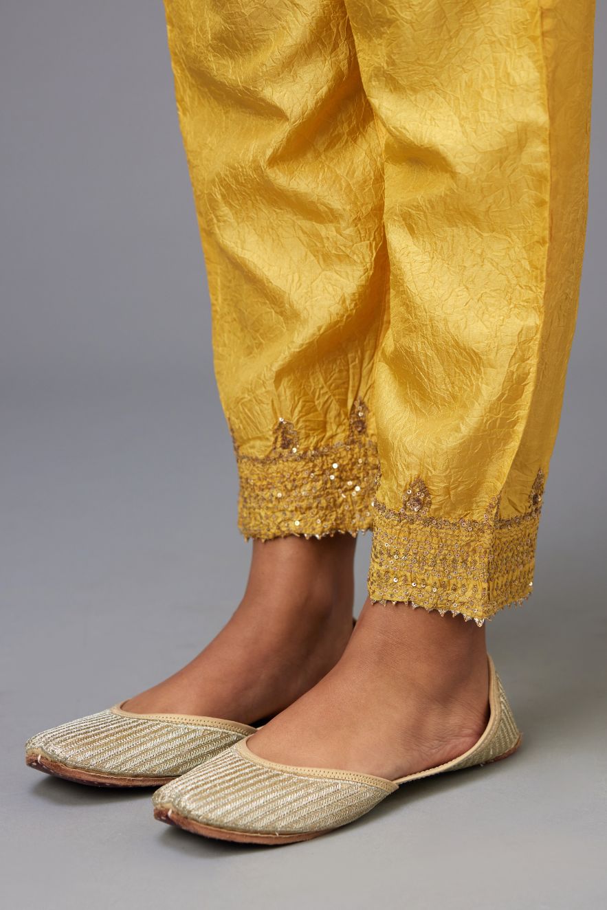 Yellow hand crushed silk pants with embroidered sequins border at hem.