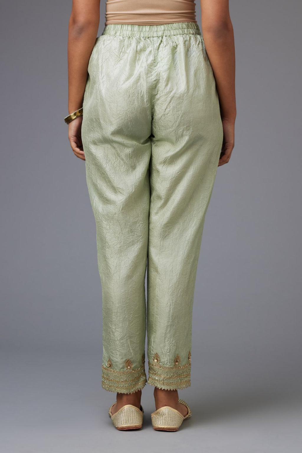 Green hand crushed silk pants with embroidered sequins border at hem.