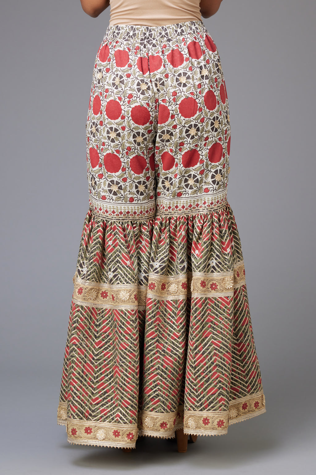 Red and green hand block printed cotton farshi detailed with sequins and gota lace.