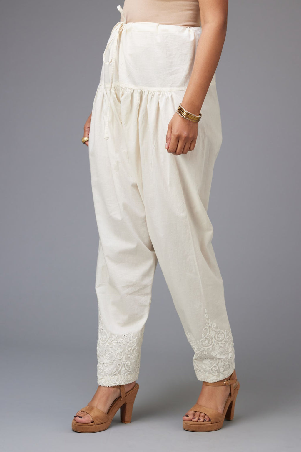 Off-white cotton narrow salwar with dori embroidery at hem.