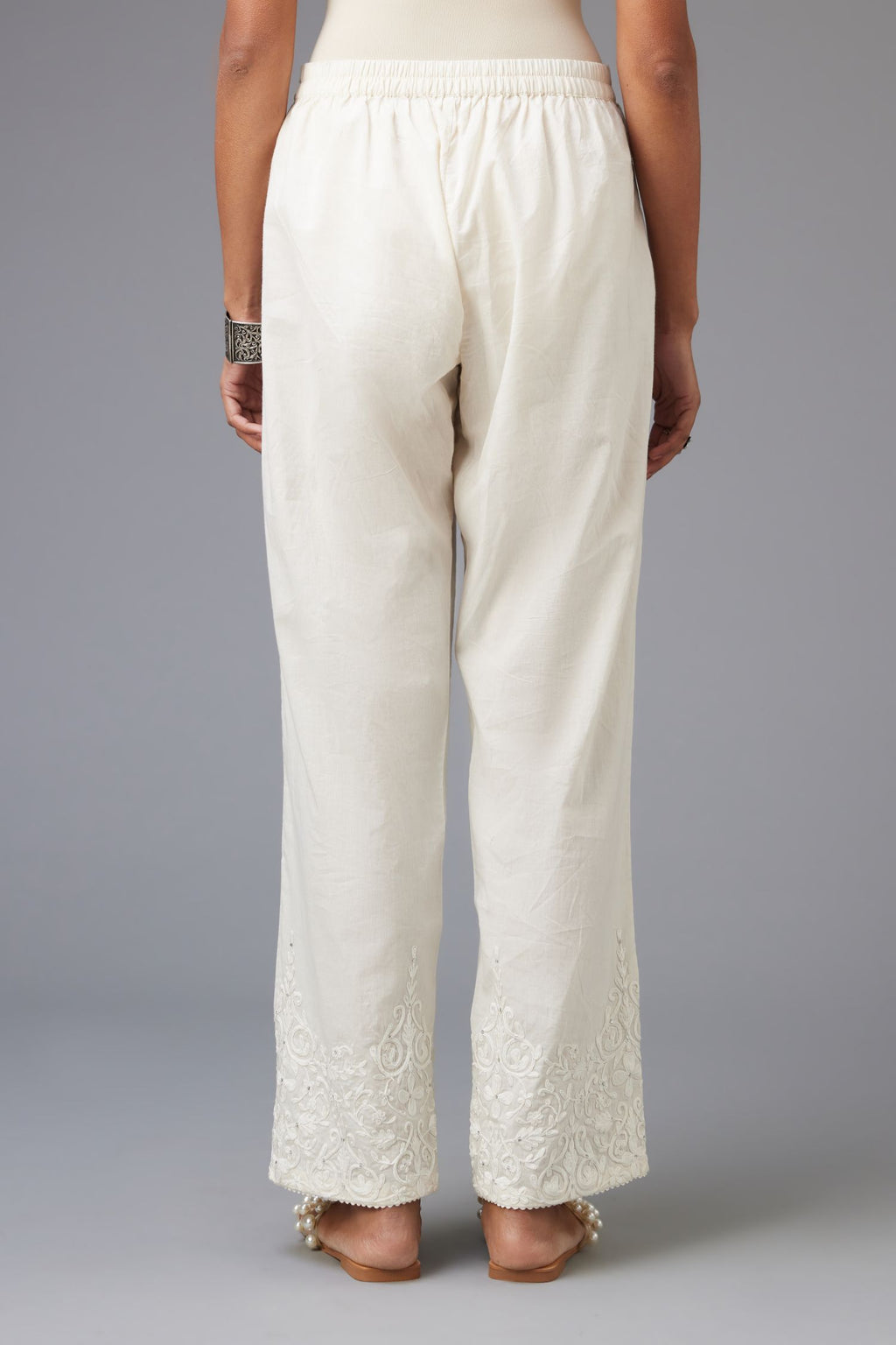Off-white cotton straight pants with dori embroidery at hem.