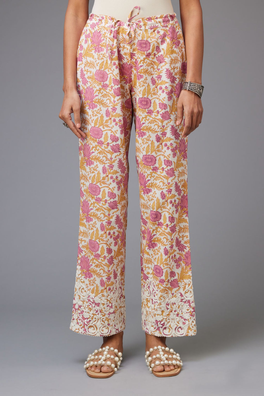 Pink and mustard hand block printed pants with dori embroidery at hem.