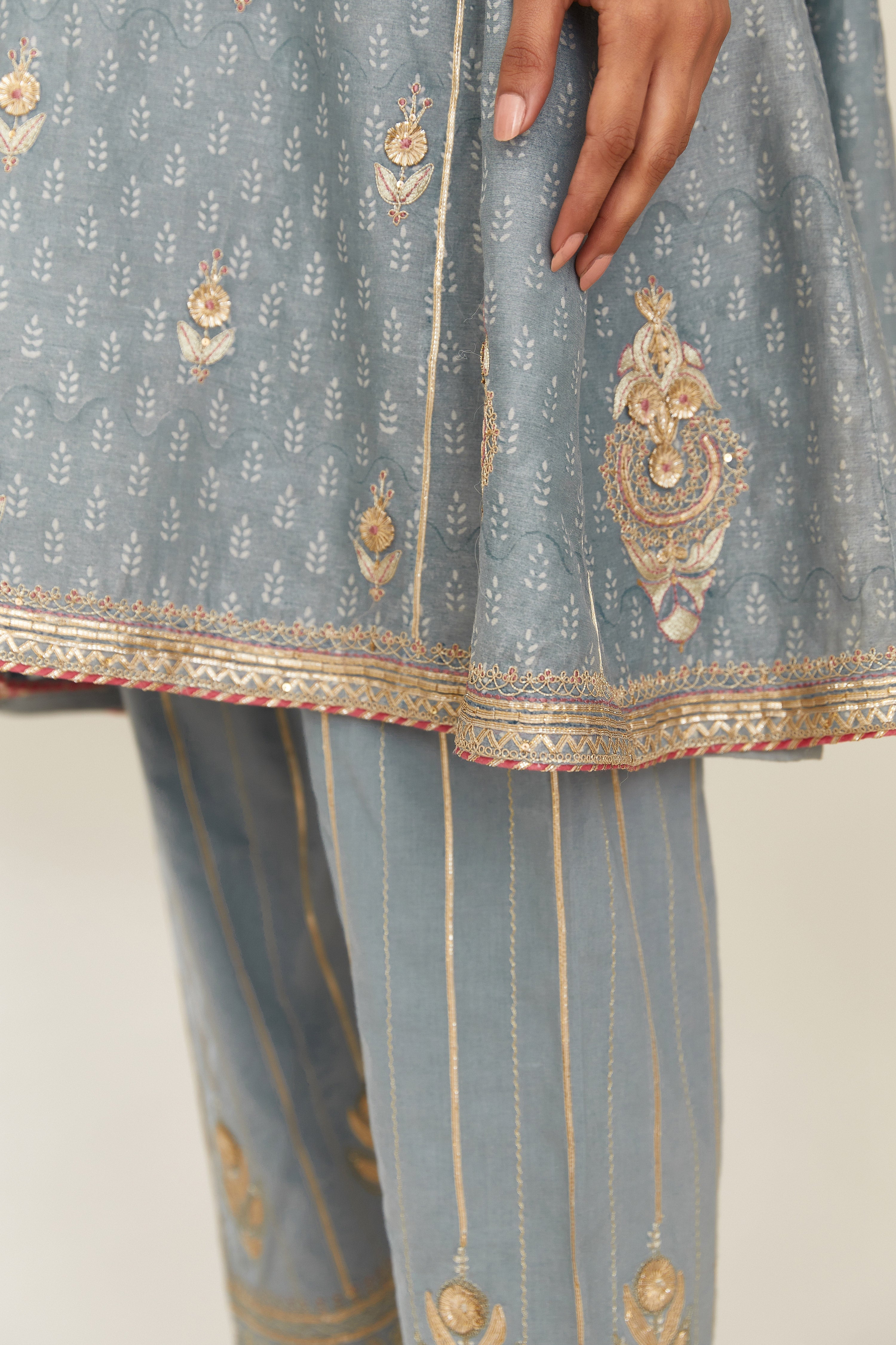 Powder blue hand block printed short kalidar silk chanderi kurta set with button placket and all over gold gota and zari embroidery.