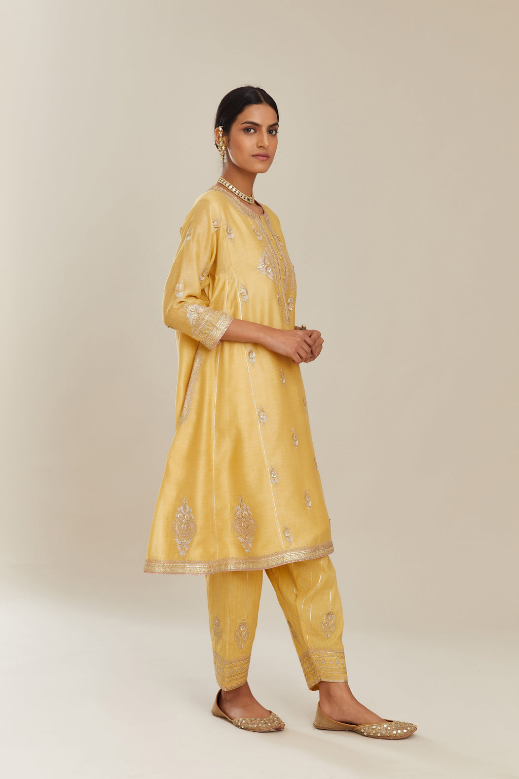 Yellow short kalidar silk chanderi kurta set with button placket and all over gold gota and zari embroidery.
