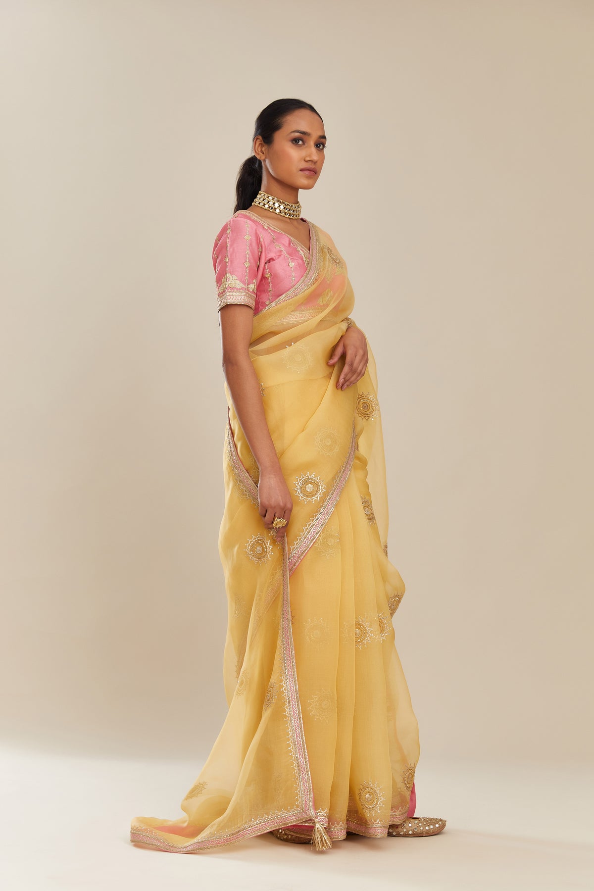 Yellow silk organza saree with delicate gold gota embroidery and contrast colored border running along all edges.