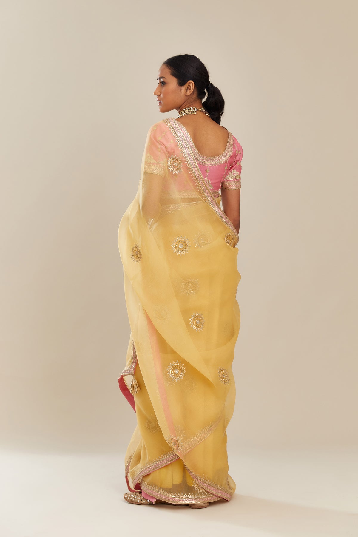 Yellow silk organza saree with delicate gold gota embroidery and contrast colored border running along all edges.