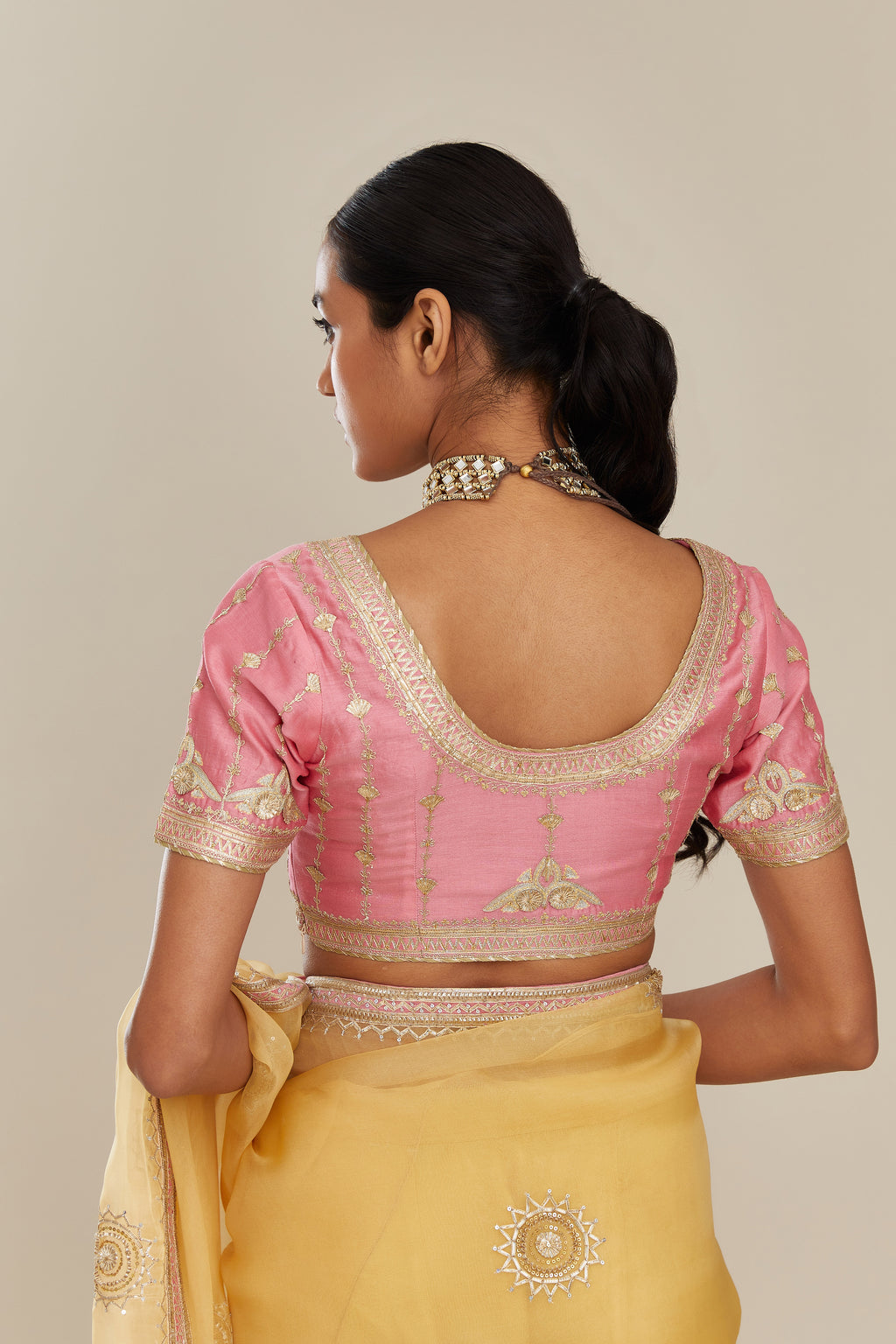 Yellow silk organza saree with delicate gold gota embroidery and contrast colored border running along all edges.