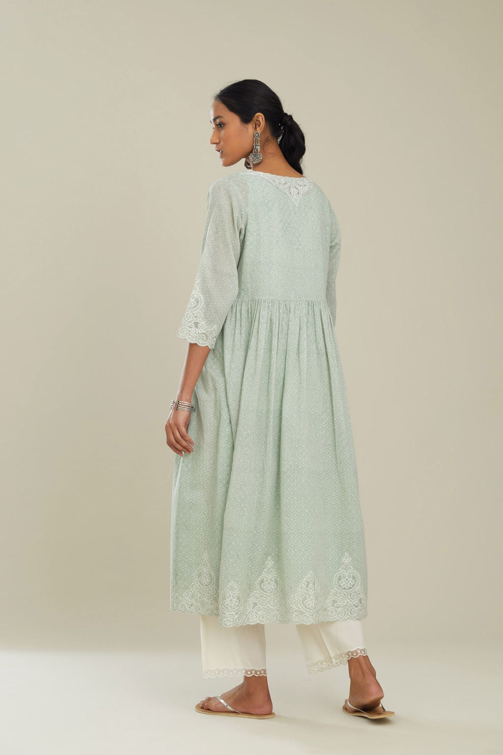 Green hand block over-printed cotton kurta set with wavy empire waistline,  gathers at wiast and cutwork detail highlighted with sequins