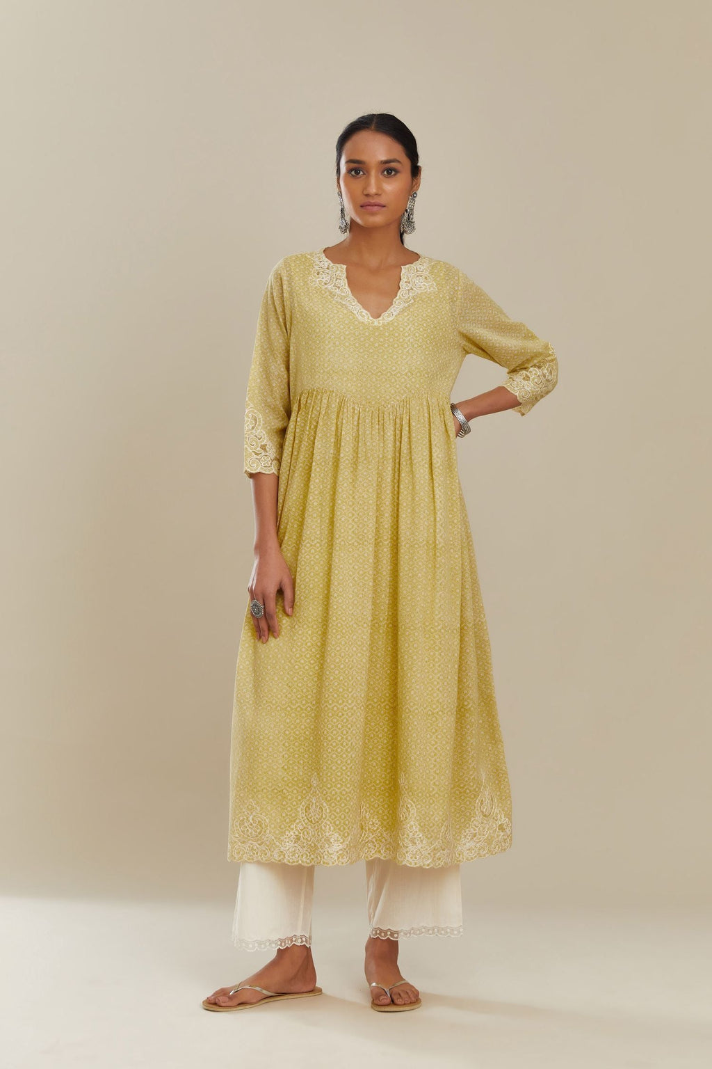 Yellow hand block over-printed cotton kurta set with wavy empire waistline,  gathers at waist and cutwork detail highlighted with sequins