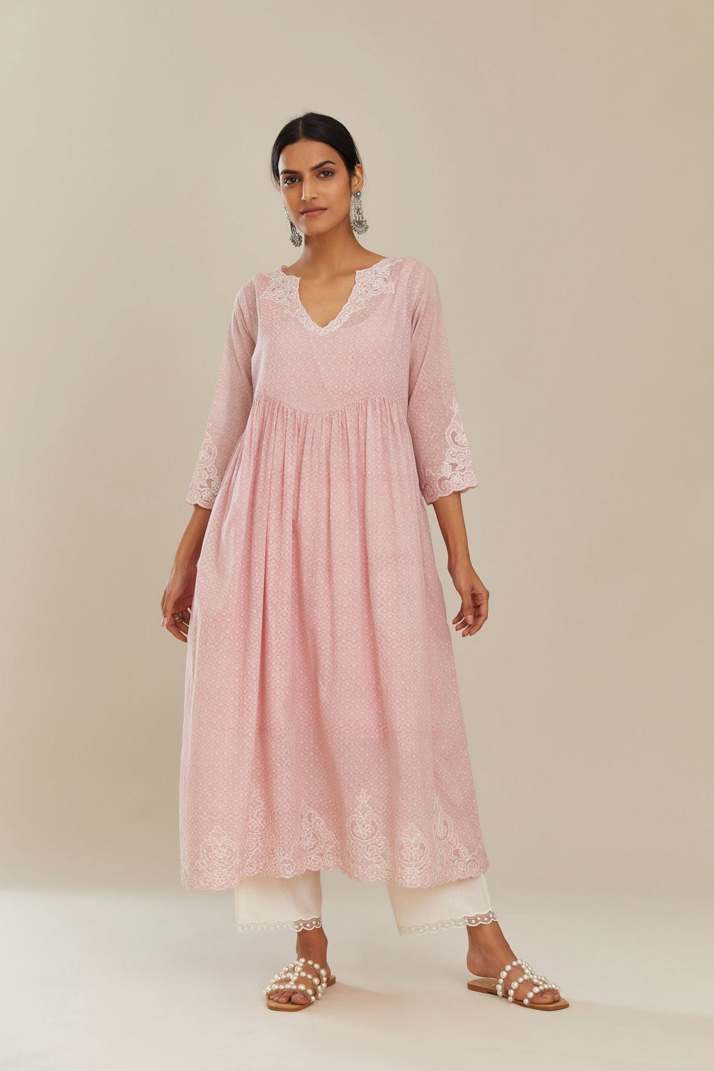 Pink hand block over-printed cotton kurta set with wavy empire waistline,  gathers at waist and cutwork detail highlighted with sequins