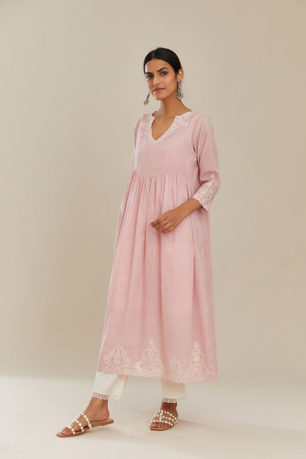 Pink hand block over-printed cotton kurta set with wavy empire waistline,  gathers at waist and cutwork detail highlighted with sequins