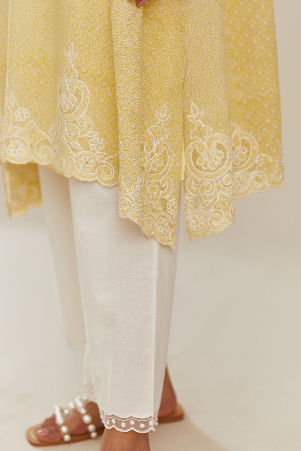 A-line hand block over-printed yellow kurta set with bell sleeves and cutwork embroidery with sequins.