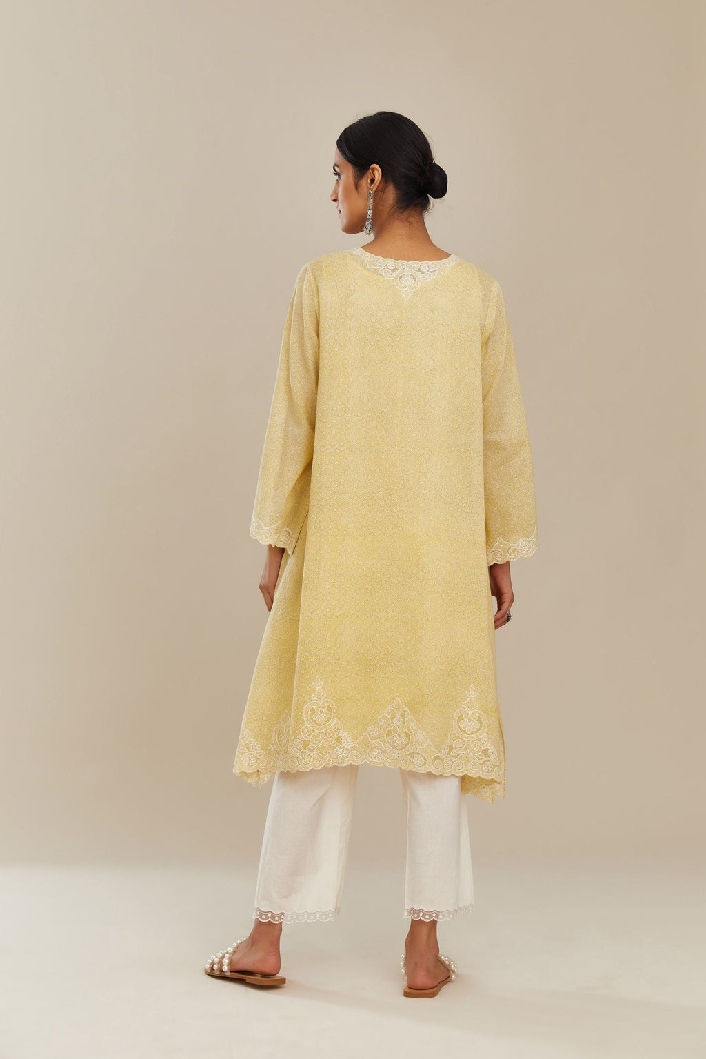 A-line hand block over-printed yellow kurta set with bell sleeves and cutwork embroidery with sequins.