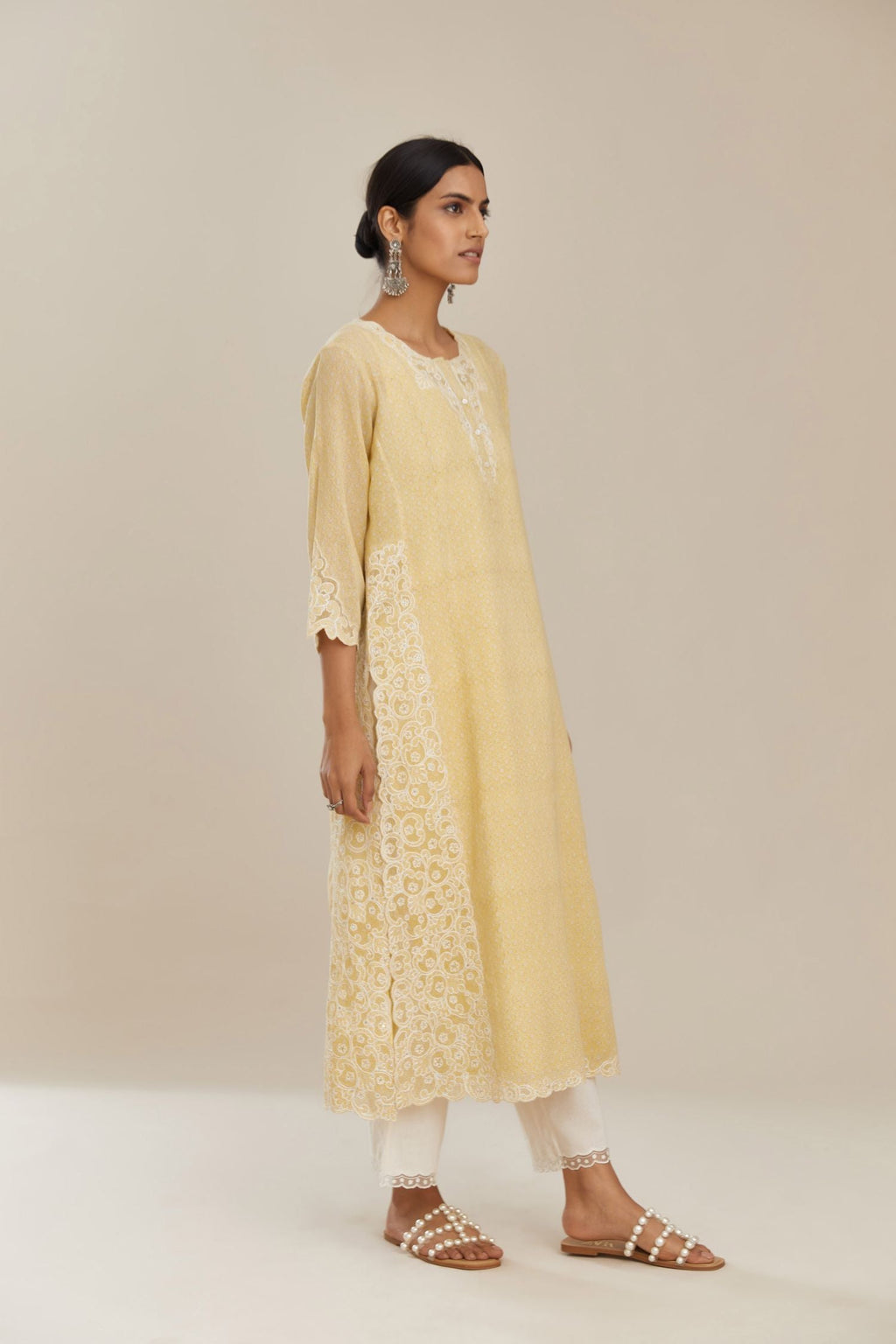 Yellow hand block over-printed cotton straight kurta set with cotton chanderi cutwork embroidery highlighted with sequins.