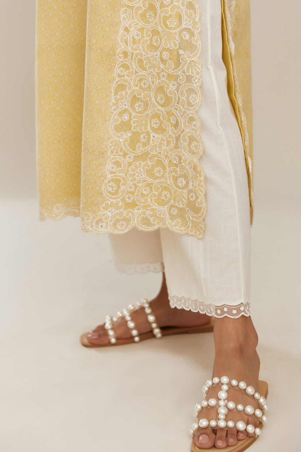 Yellow hand block over-printed cotton straight kurta set with cotton chanderi cutwork embroidery highlighted with sequins.