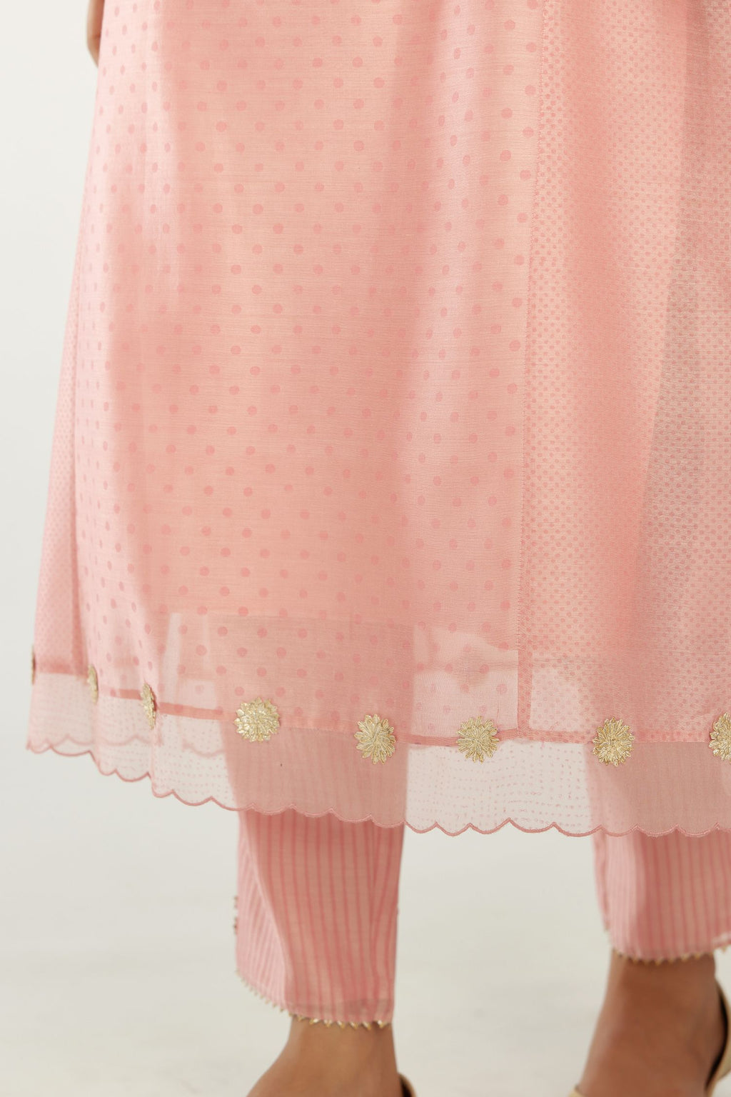 Pink hand block printed silk chanderi kurta set with concealed button placket neckline, Highlighted with gota flower and scalloped organza at edges.