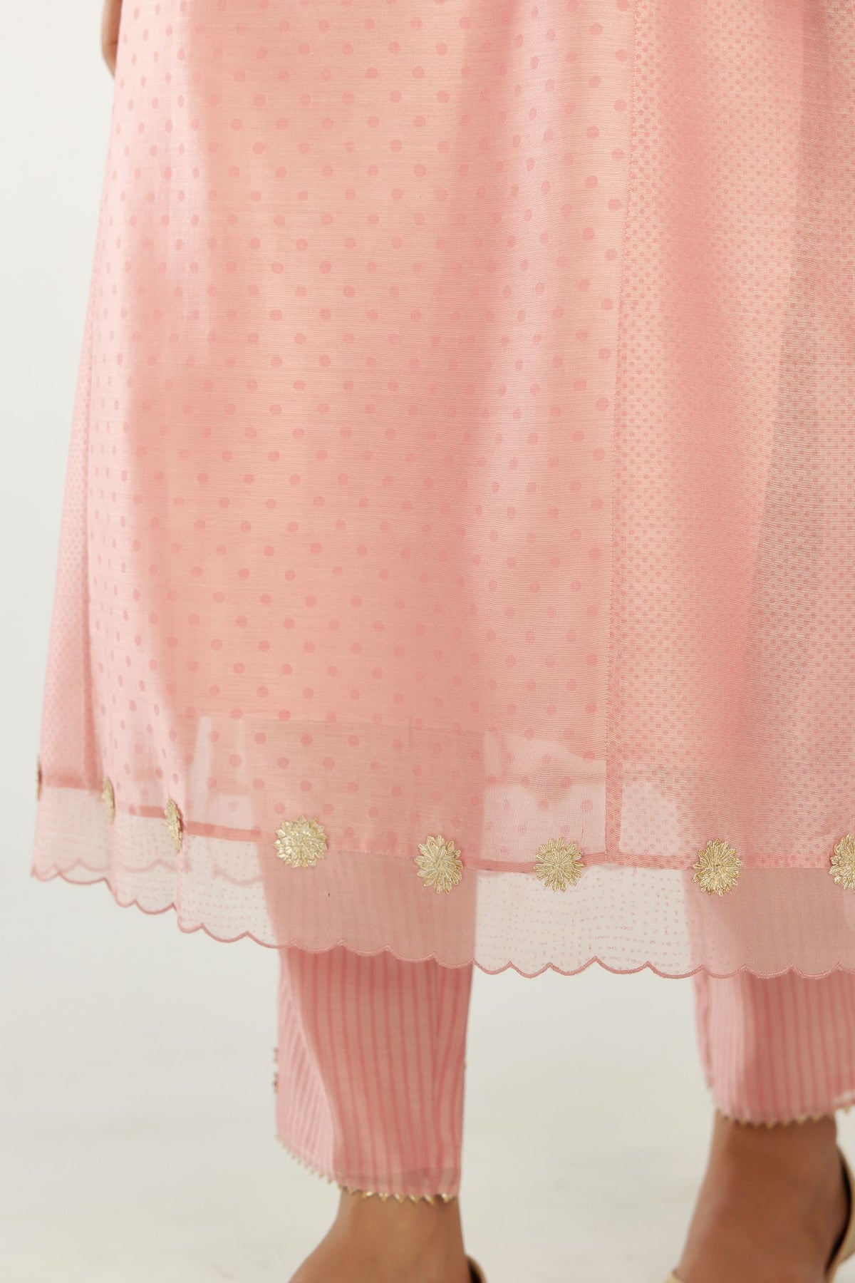 Pink hand block printed silk chanderi kurta set with concealed button placket neckline, Highlighted with gota flower and scalloped organza at edges.