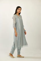 Blue silk chanderi hand block printed straight kurta set with concealed button placket neckline, highlighted with scalloped organza at edges.