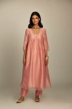 Pink hand block printed V neck gathered kurta set, highlighted with gota flower embroidery and scalloped organza at edges.