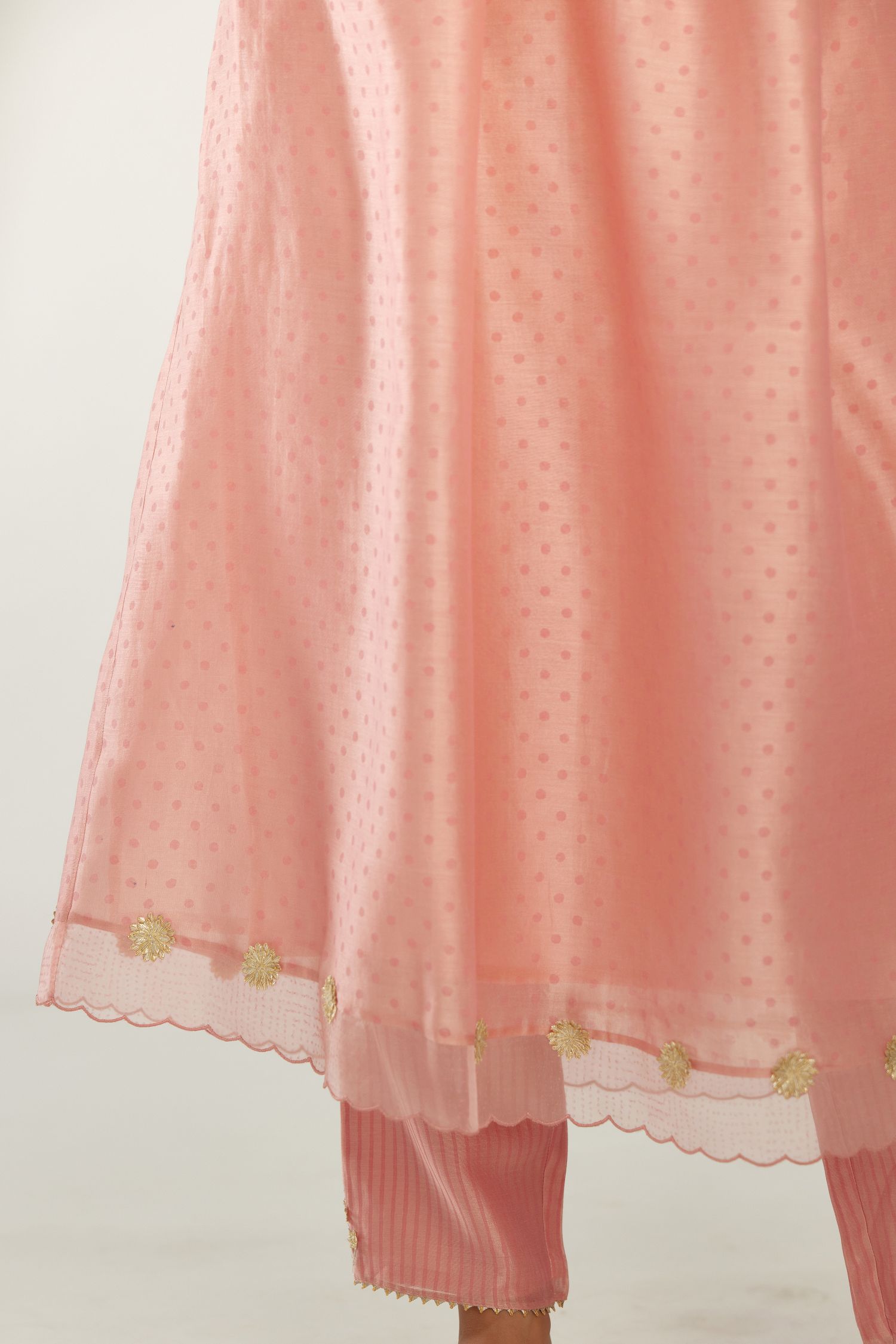 Pink hand block printed V neck gathered kurta set, highlighted with gota flower embroidery and scalloped organza at edges.
