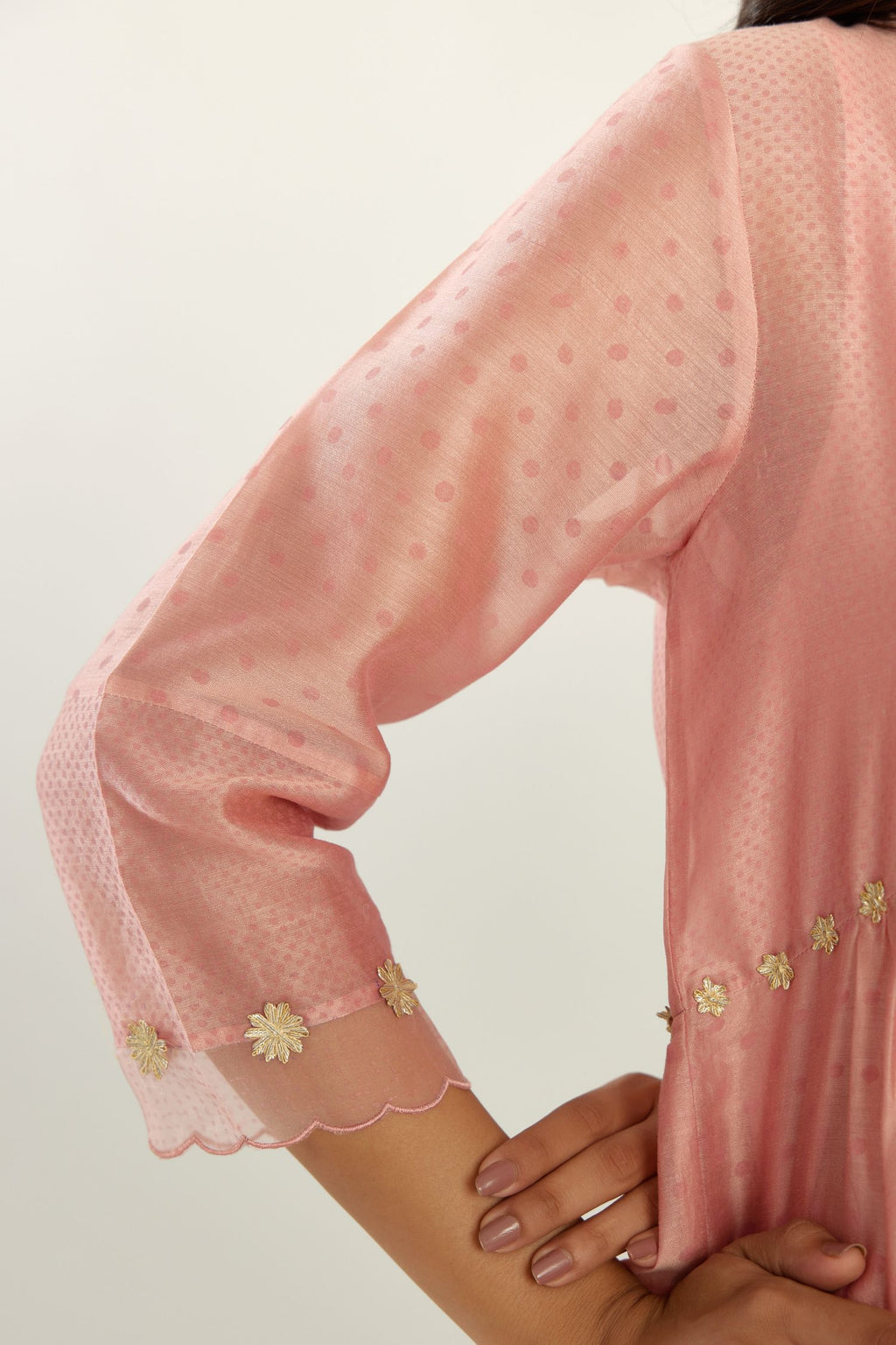 Pink hand block printed V neck gathered kurta set, highlighted with gota flower embroidery and scalloped organza at edges.