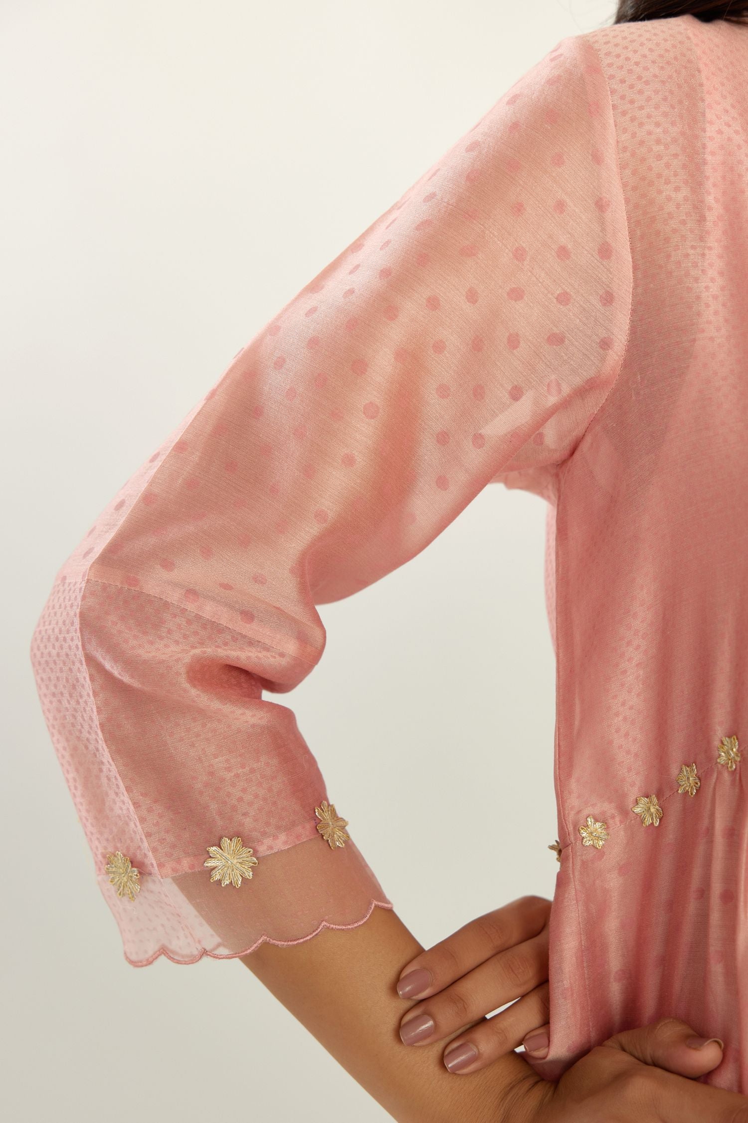 Pink hand block printed V neck gathered kurta set, highlighted with gota flower embroidery and scalloped organza at edges.
