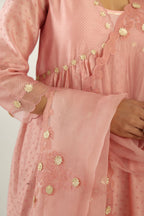 Pink hand block printed V neck gathered kurta set, highlighted with gota flower embroidery and scalloped organza at edges.