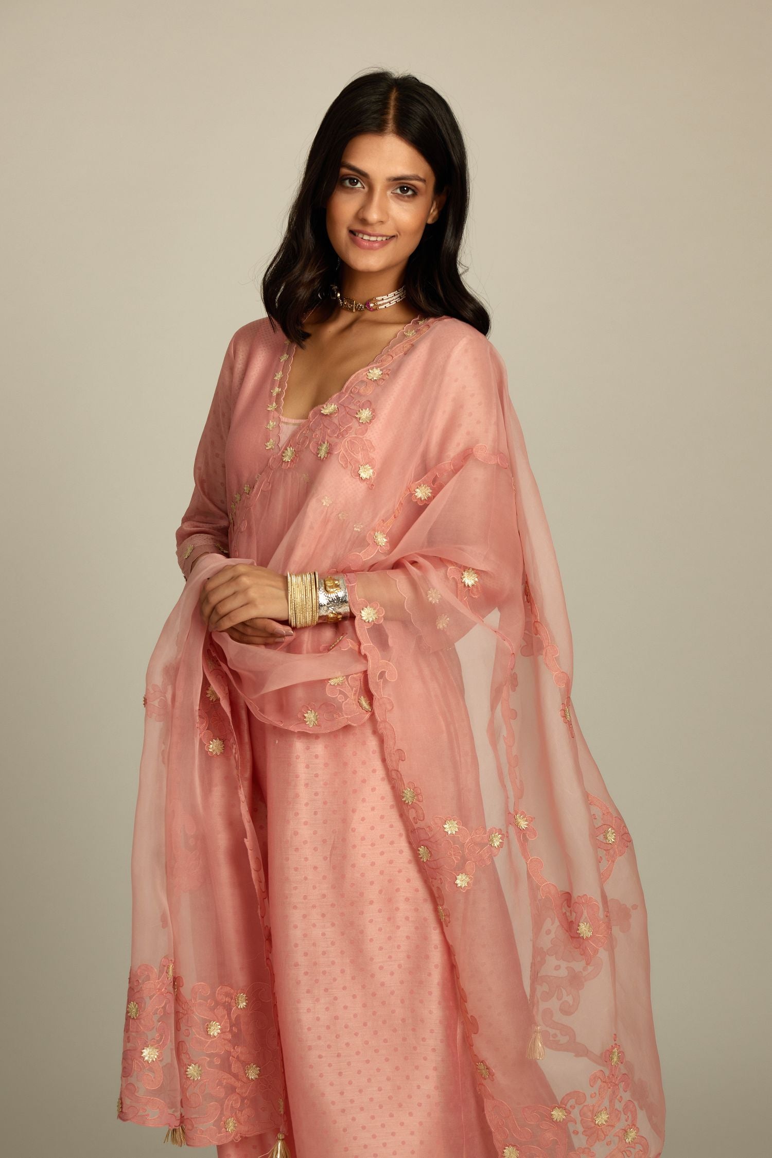 Pink hand block printed V neck gathered kurta set, highlighted with gota flower embroidery and scalloped organza at edges.