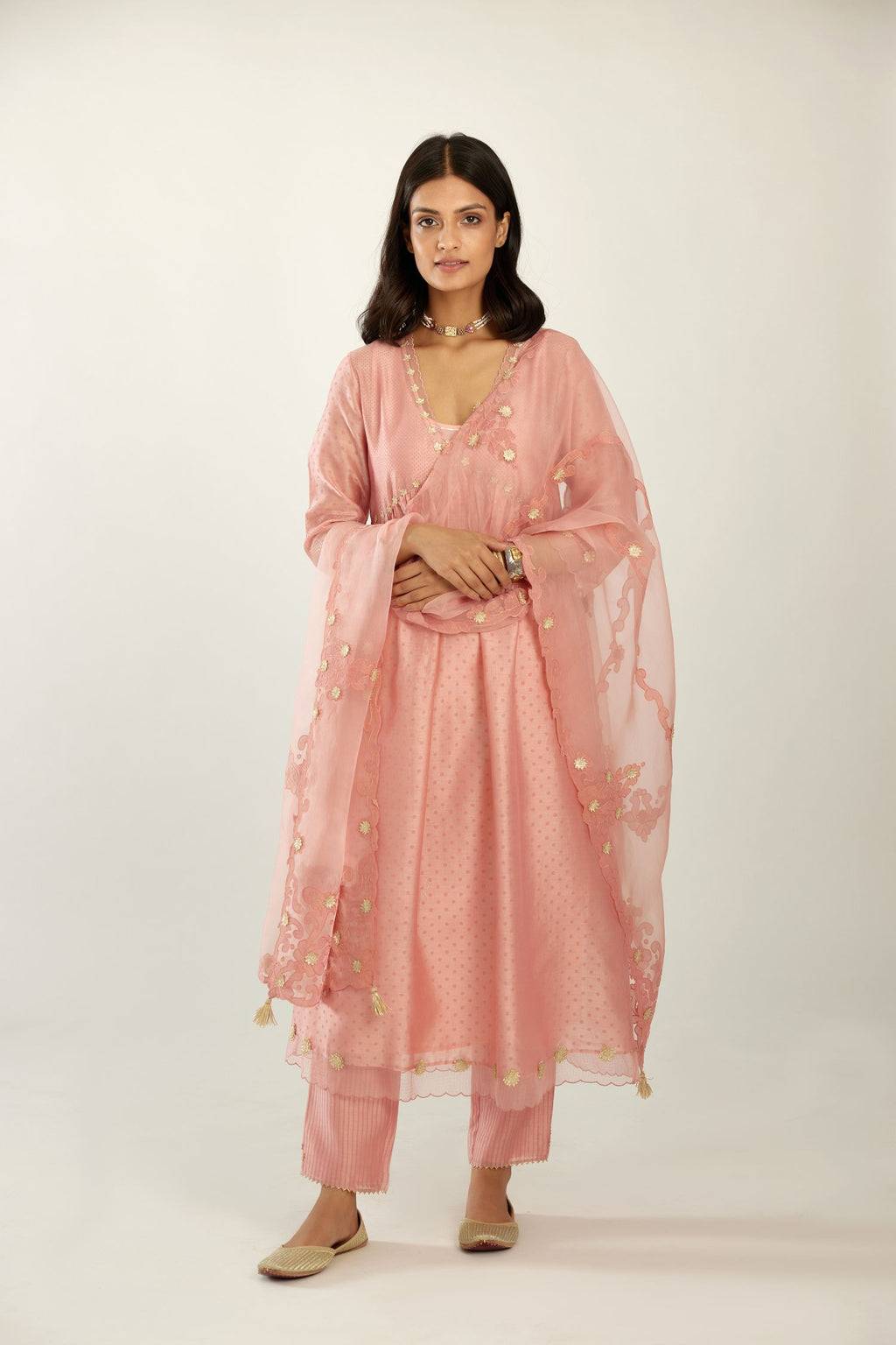 Pink hand block printed V neck gathered kurta set, highlighted with gota flower embroidery and scalloped organza at edges.