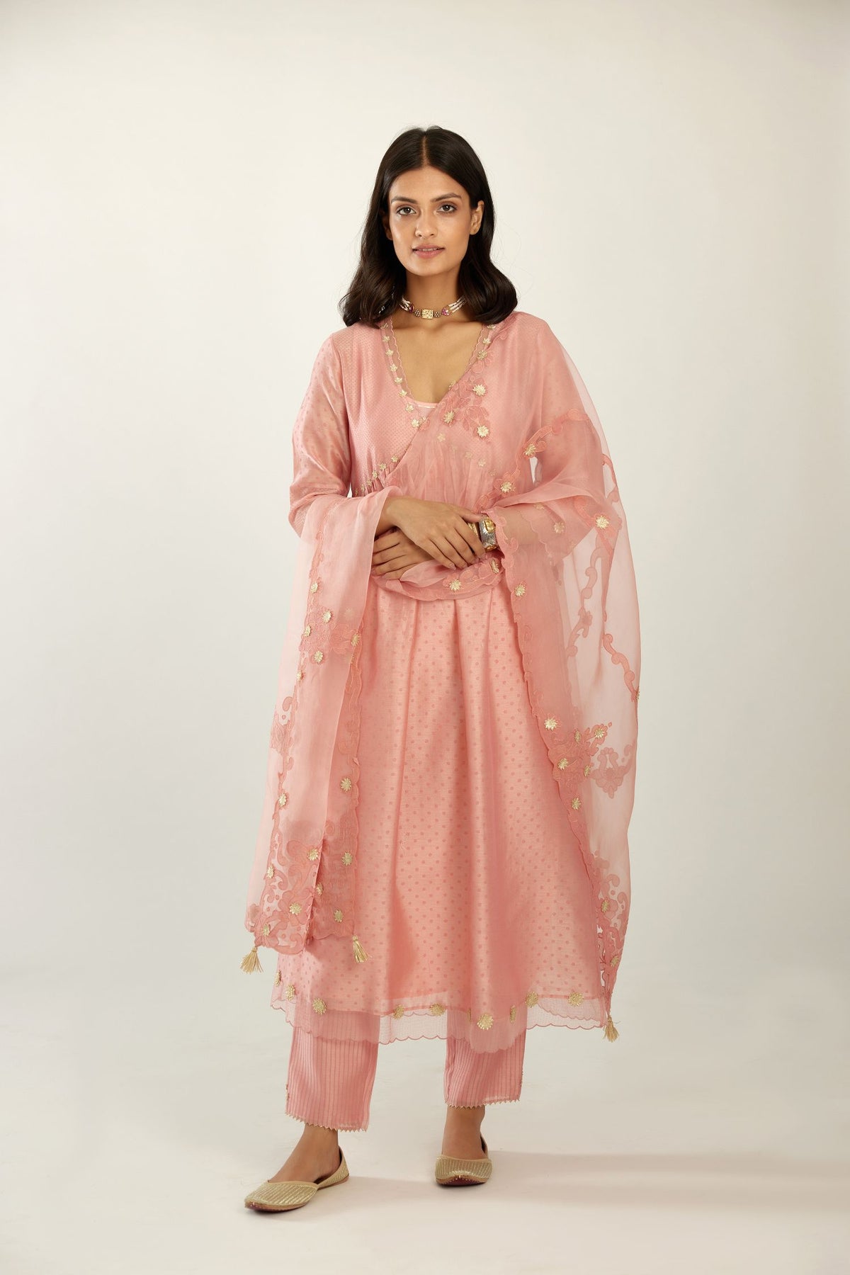 Pink hand block printed V neck gathered kurta set, highlighted with gota flower embroidery and scalloped organza at edges.