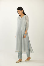 Blue hand block printed silk chanderi kurta set with concealed button placket neckline, Highlighted with gota flower and scalloped organza at edges.