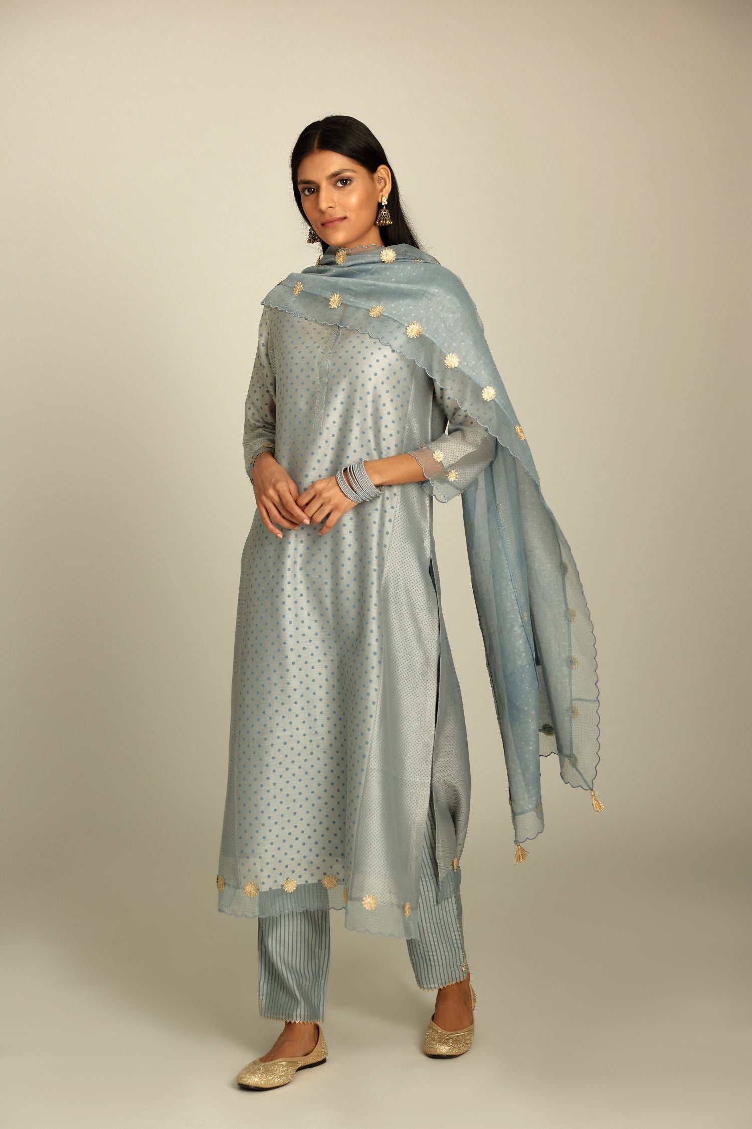 Blue hand block printed silk chanderi kurta set with concealed button placket neckline, Highlighted with gota flower and scalloped organza at edges.