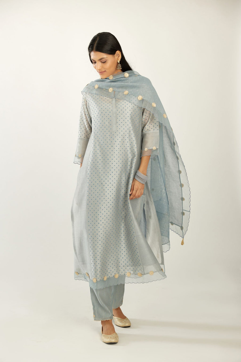 Blue hand block printed silk chanderi kurta set with concealed button placket neckline, Highlighted with gota flower and scalloped organza at edges.