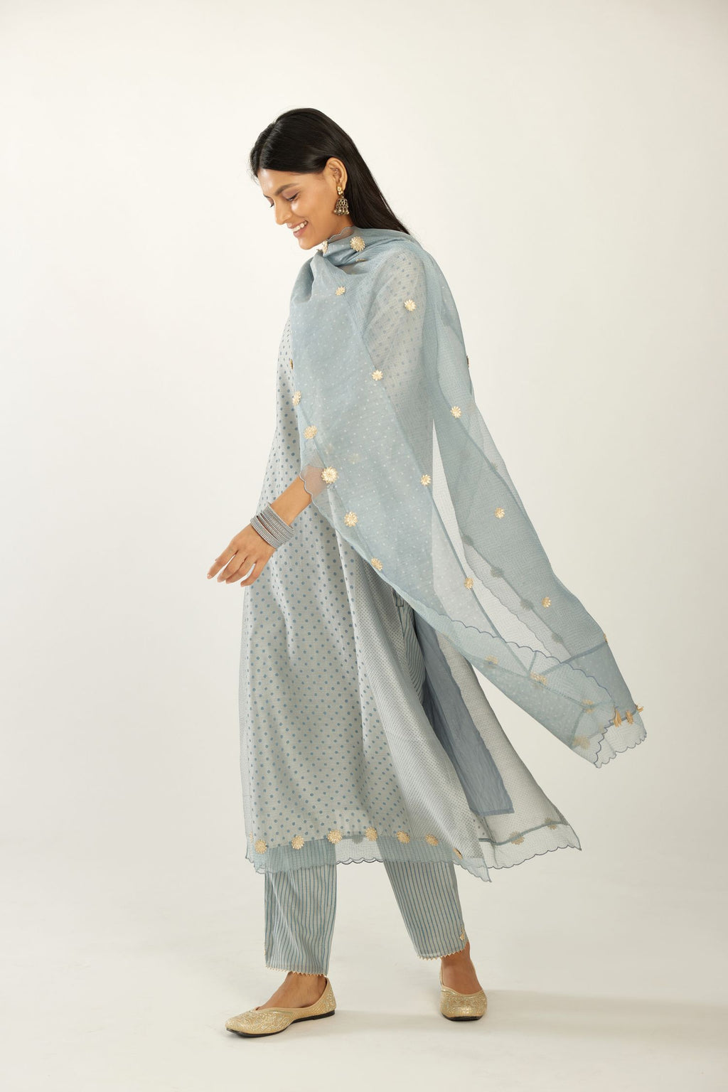 Blue hand block printed silk chanderi kurta set with concealed button placket neckline, Highlighted with gota flower and scalloped organza at edges.