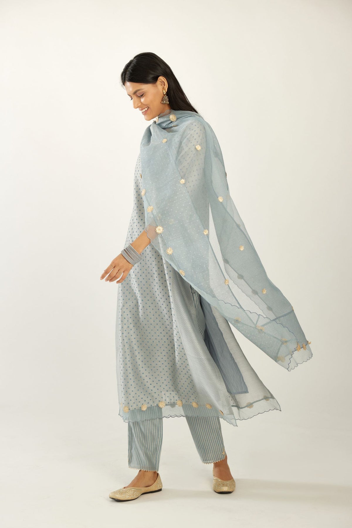 Blue hand block printed silk chanderi kurta set with concealed button placket neckline, Highlighted with gota flower and scalloped organza at edges.