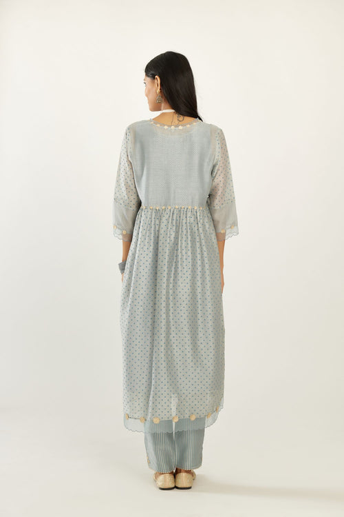 Blue hand block printed V neck gathered kurta set, highlighted with gota flower embroidery and scalloped organza at edges.
