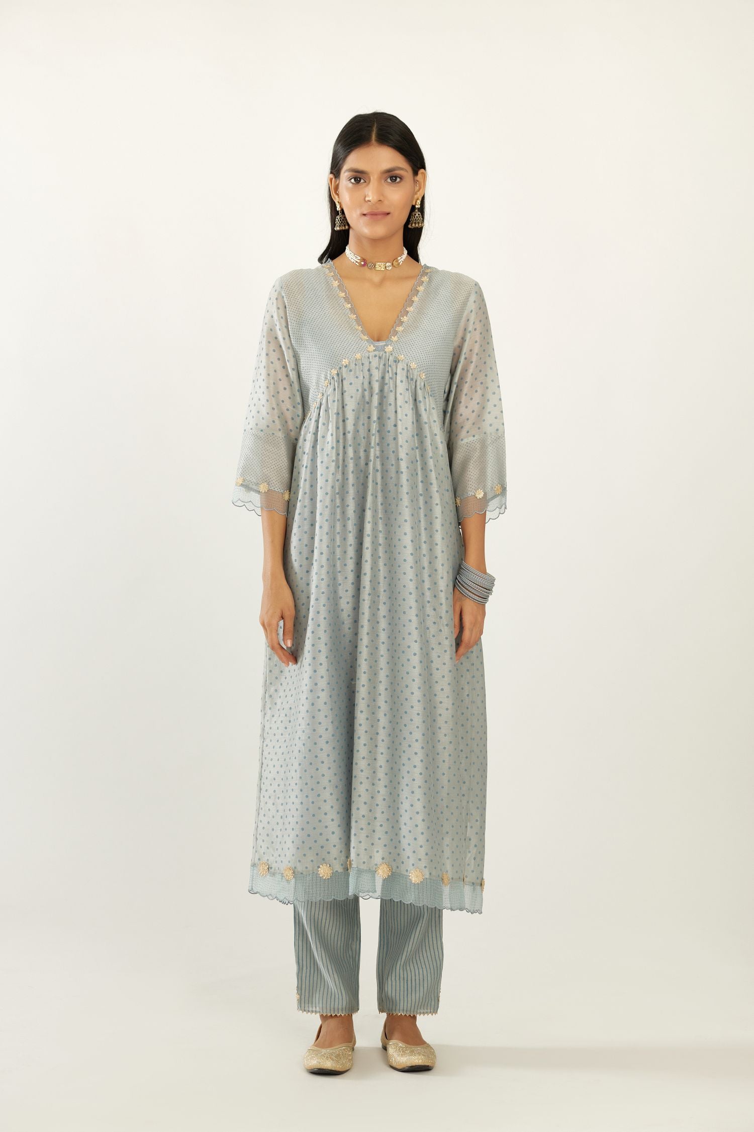 Blue hand block printed V neck gathered kurta set, highlighted with gota flower embroidery and scalloped organza at edges.
