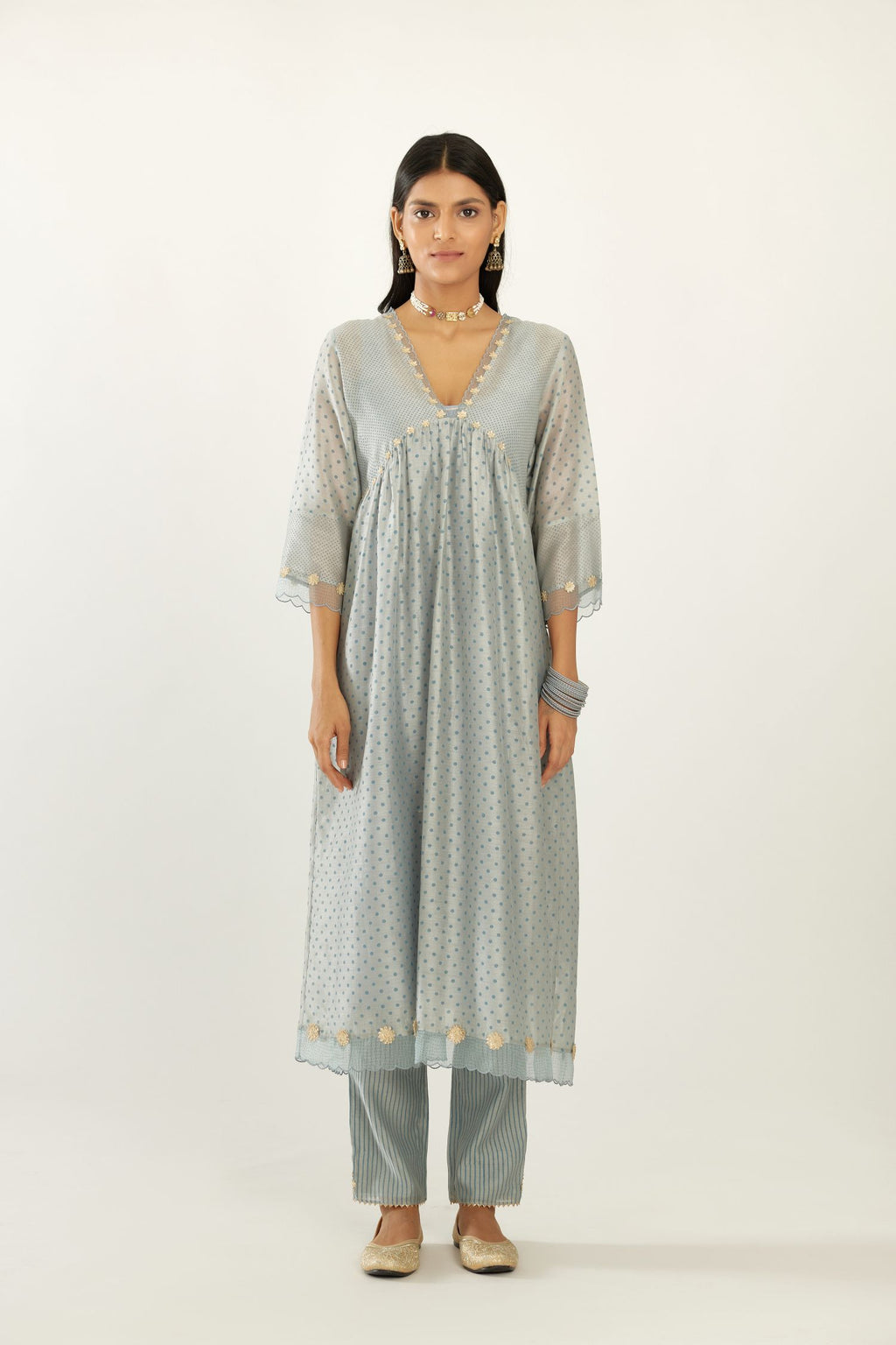 Blue hand block printed V neck gathered kurta set, highlighted with gota flower embroidery and scalloped organza at edges.