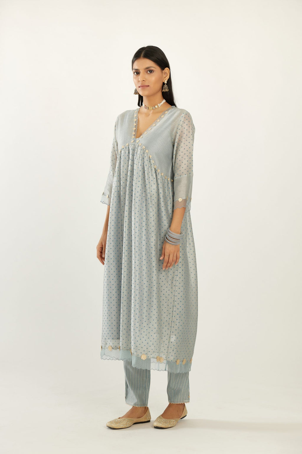 Blue hand block printed V neck gathered kurta set, highlighted with gota flower embroidery and scalloped organza at edges.