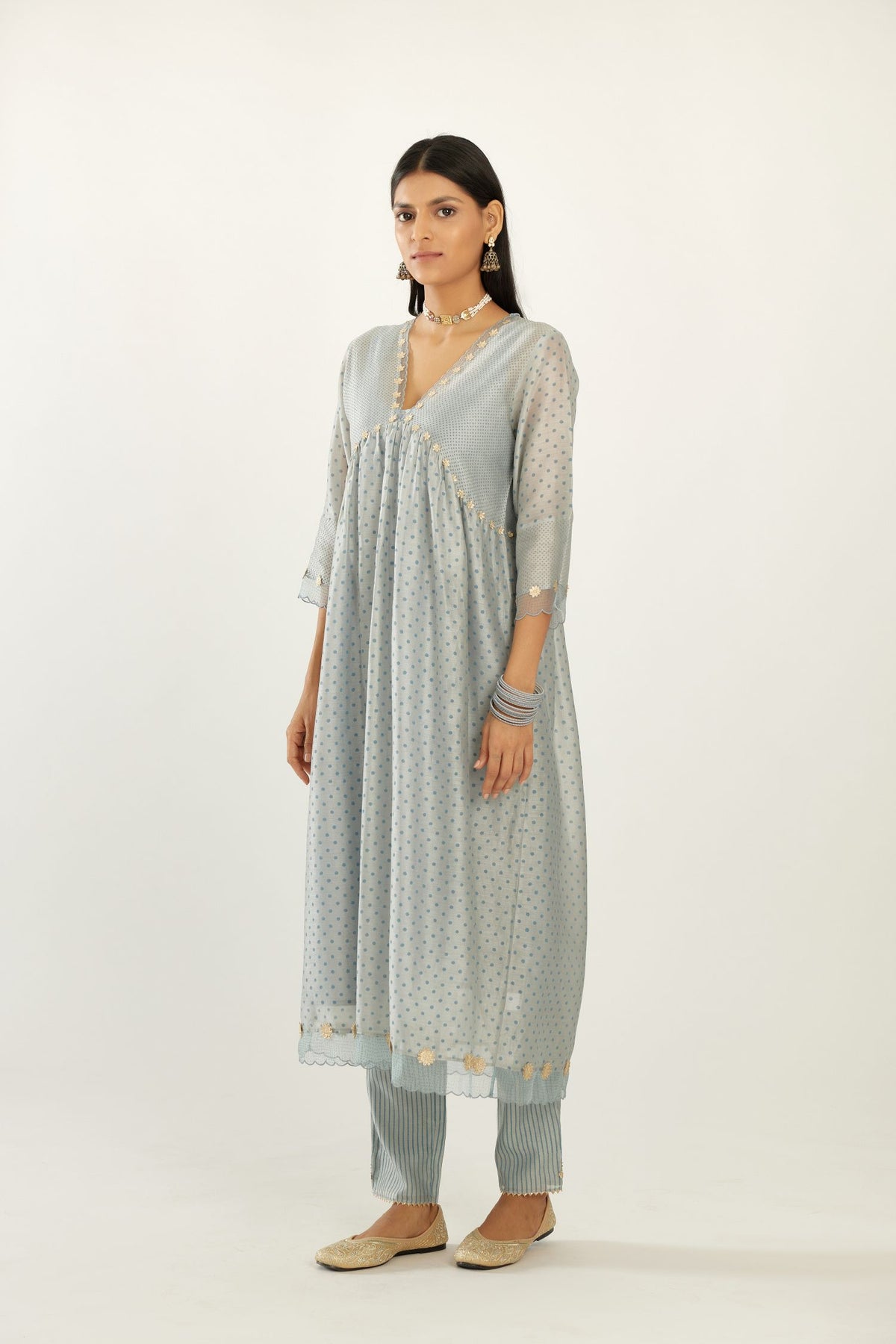 Blue hand block printed V neck gathered kurta set, highlighted with gota flower embroidery and scalloped organza at edges.